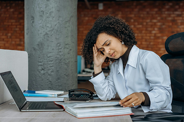 Woman frowning at sheets in a report book